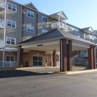 A multi-story residential building with a covered entrance.