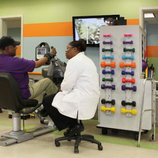 A healthcare professional discusses treatment with a patient in a rehabilitation center.