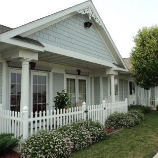 A charming house with a white picket fence and a well-maintained garden.