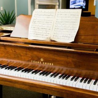A grand piano with sheet music placed on the stand.