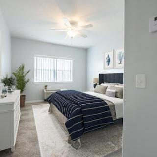 A serene and modern bedroom featuring a cozy bed, stylish decor, and ample natural light.