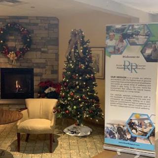 A warm and inviting space decorated for the holidays, featuring a beautifully adorned Christmas tree and a cozy fireplace.