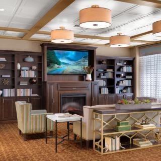 A cozy living room with a fireplace, bookshelves, and comfortable seating.