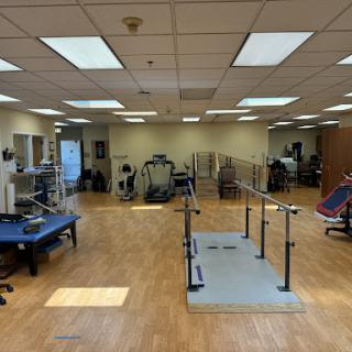 A spacious physical therapy facility equipped with various exercise and rehabilitation tools.