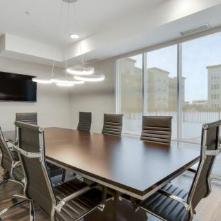A modern conference room with a large table, sleek chairs, and ample natural light.
