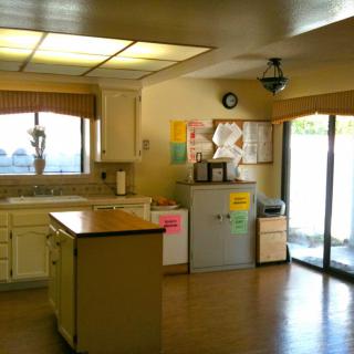 A bright kitchen interior featuring a central island and wooden flooring.