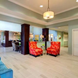 A modern lobby area featuring bright red chairs and contemporary lighting.