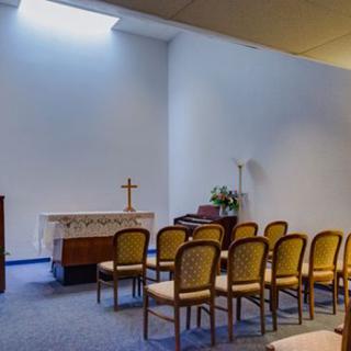 A small chapel with an altar and arranged seating.