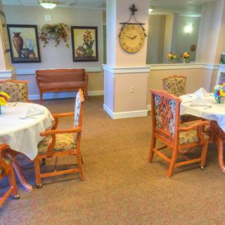 A cozy dining area featuring tables and chairs with decorative artwork on the walls.