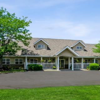 A suburban residential building with a neatly maintained lawn and trees.
