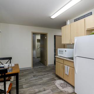 A modern kitchen with appliances and a dining area in an apartment.