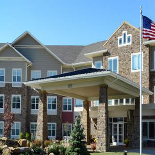 A modern commercial building with a prominent entrance and flag display.
