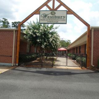 Entrance to a residential facility with a welcoming structure and landscaped surroundings.