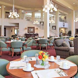 An elegant dining area with neatly arranged tables, chairs, and chandeliers.