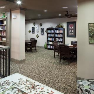 A quiet library interior with bookshelves, tables, and chairs arranged for reading.