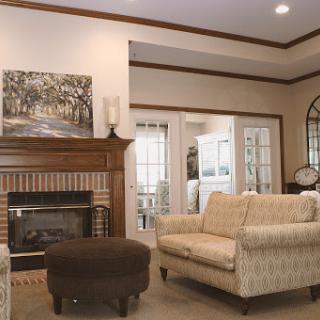 A cozy living room featuring comfortable seating, a fireplace, and tasteful artwork.