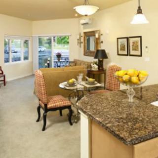 Open-concept living room and kitchen with stylish decor and granite countertops.