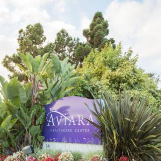 Entrance sign for Aviara Resort surrounded by lush greenery.