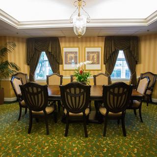 A well-decorated dining room with a large table, chairs, and elegant furnishings.
