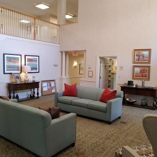 A well-decorated lobby area featuring comfortable couches and artwork on the walls.