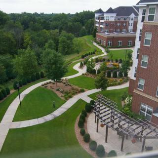 A scenic view of apartments with winding pathways and lush landscaping.