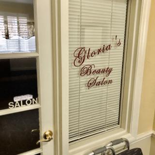A door with a window displaying the sign 'Glenda's Beauty Salon'.