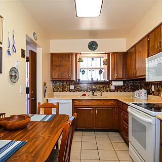 A cozy kitchen with wooden cabinets and a dining table set for meals.