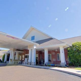 A building entrance with large columns on a sunny day.
