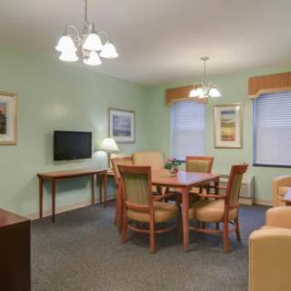 A cozy living and dining area with a table, chairs, and a television set.