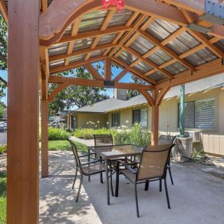 A cozy outdoor patio area with a pergola providing shade over a table and chairs.