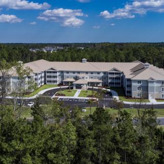 Aerial view of a large residential building surrounded by trees.