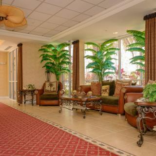 A beautifully decorated lobby area with elegant furniture and lush green plants.
