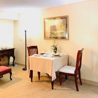 A cozy dining area with a small table set for two, complete with elegant chairs and soft lighting.