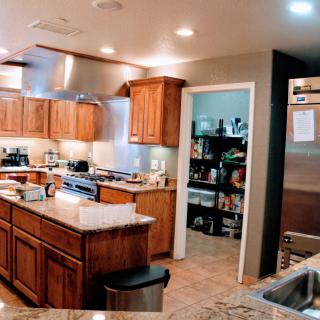 A modern kitchen with wooden cabinets, a central island, and stainless steel appliances.