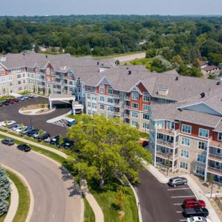 Aerial view of a residential community with colorful buildings and a surrounding landscape.
