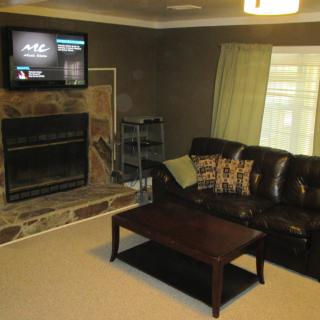 A cozy living room with a fireplace, television, and comfortable seating.