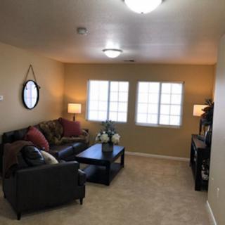 A cozy living room with a sofa, coffee table, and soft lighting.