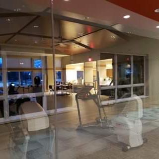 A view of a fitness area with exercise equipment visible through glass, showcasing a modern interior space.