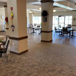 Spacious dining area with tables and chairs, featuring large windows.