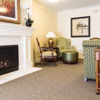 A cozy living room with a fireplace, comfortable seating, and tasteful decor.