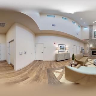 A spacious and elegantly designed living room featuring modern furniture and a warm color palette.