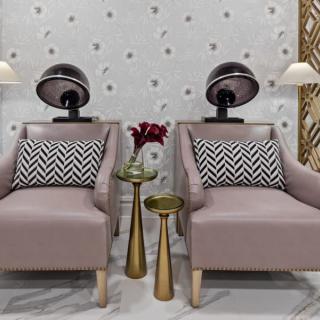 A stylish salon seating area with comfortable chairs and mounted hair dryers.