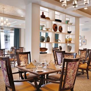An elegantly designed dining area with decorative shelves and stylish furniture.