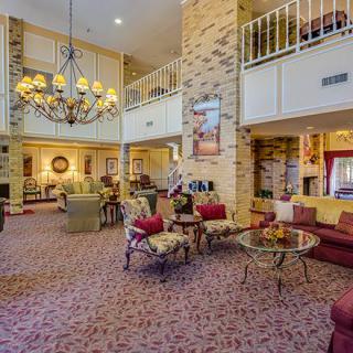 A spacious hotel lobby with elegant decor, featuring a large chandelier and comfortable seating areas.