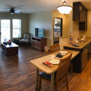 A cozy open floor plan featuring a living room, kitchen, and dining area with wood flooring.