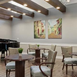 A modern seating area featuring a grand piano and vibrant artwork on the walls.