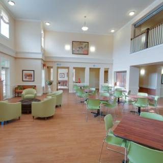 A spacious community center interior with tables and chairs arranged for gatherings.