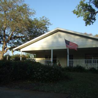 A suburban house with a porch and an American flag.