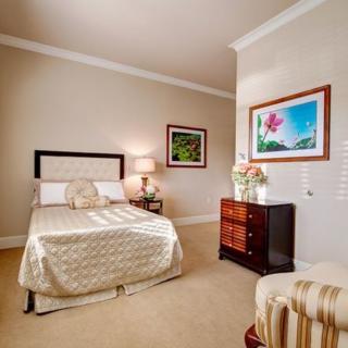 A cozy bedroom featuring elegant decor with a bed, nightstand, and artwork on the walls.