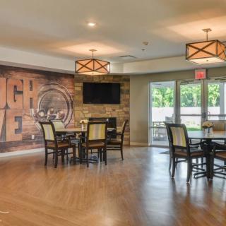 A modern dining area with a mural wall, featuring tables, chairs, and stylish lighting fixtures.